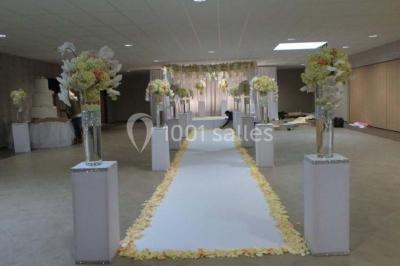 Salle de réception avec bar éclairé par des lumières colorées et invités rassemblés dans une ambiance tamisée.