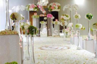 Salle de réception avec bar éclairé par des lumières colorées et invités rassemblés dans une ambiance tamisée.
