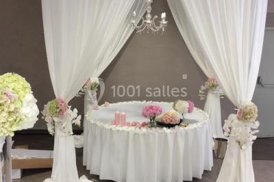 Salle de réception avec bar éclairé par des lumières colorées et invités rassemblés dans une ambiance tamisée.