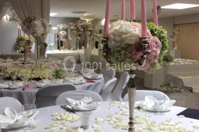 Salle de réception avec bar éclairé par des lumières colorées et invités rassemblés dans une ambiance tamisée.