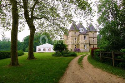 Comptoir d'accueil noir brillant dans un espace lumineux avec un sol en pierre et une plante en pot près d'une fenêtre.