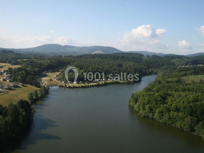 Vue aérienne d'une rivière sinueuse entourée de forêts et de collines sous un ciel dégagé.