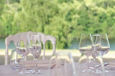 Lavabo avec plan en bois, sèche-serviettes mural, douche avec paroi vitrée et carrelage sombre.