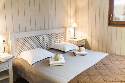 Lavabo avec plan en bois, sèche-serviettes mural, douche avec paroi vitrée et carrelage sombre.