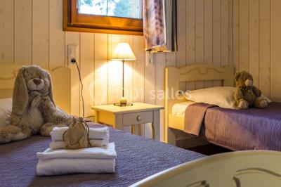 Lavabo avec plan en bois, sèche-serviettes mural, douche avec paroi vitrée et carrelage sombre.