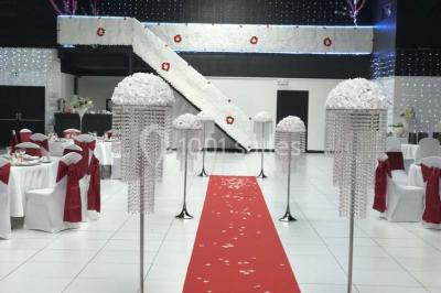 Salle de conférence avec des rangées de chaises vides, éclairée par des guirlandes lumineuses sur les murs.