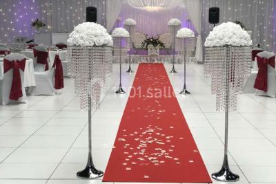 Salle de conférence avec des rangées de chaises vides, éclairée par des guirlandes lumineuses sur les murs.