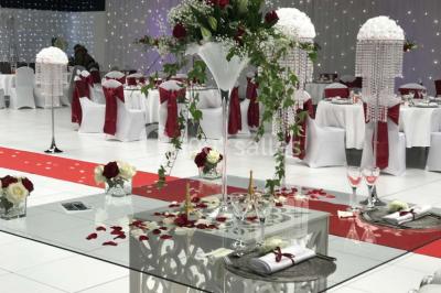 Salle de conférence avec des rangées de chaises vides, éclairée par des guirlandes lumineuses sur les murs.