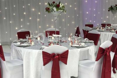 Salle de conférence avec des rangées de chaises vides, éclairée par des guirlandes lumineuses sur les murs.