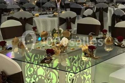 Salle de conférence avec des rangées de chaises vides, éclairée par des guirlandes lumineuses sur les murs.