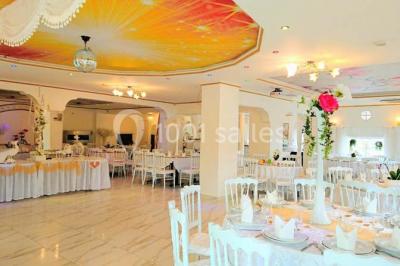 Décoration intérieure avec comptoir en marbre, plantes, ballons dorés et blancs disposés sur une structure décorative.