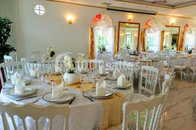 Décoration intérieure avec comptoir en marbre, plantes, ballons dorés et blancs disposés sur une structure décorative.