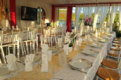 Décoration intérieure avec comptoir en marbre, plantes, ballons dorés et blancs disposés sur une structure décorative.