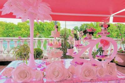 Décoration intérieure avec comptoir en marbre, plantes, ballons dorés et blancs disposés sur une structure décorative.