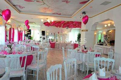 Décoration intérieure avec comptoir en marbre, plantes, ballons dorés et blancs disposés sur une structure décorative.