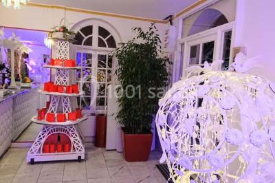 Décoration intérieure avec comptoir en marbre, plantes, ballons dorés et blancs disposés sur une structure décorative.