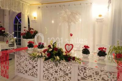 Décoration intérieure avec comptoir en marbre, plantes, ballons dorés et blancs disposés sur une structure décorative.