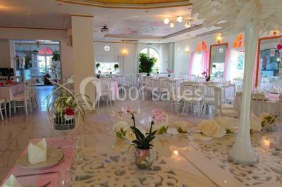 Décoration intérieure avec comptoir en marbre, plantes, ballons dorés et blancs disposés sur une structure décorative.