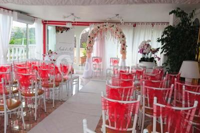 Décoration intérieure avec comptoir en marbre, plantes, ballons dorés et blancs disposés sur une structure décorative.