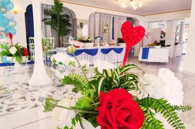 Décoration intérieure avec comptoir en marbre, plantes, ballons dorés et blancs disposés sur une structure décorative.