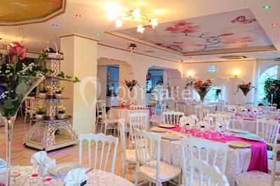 Décoration intérieure avec comptoir en marbre, plantes, ballons dorés et blancs disposés sur une structure décorative.