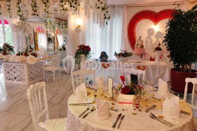 Décoration intérieure avec comptoir en marbre, plantes, ballons dorés et blancs disposés sur une structure décorative.