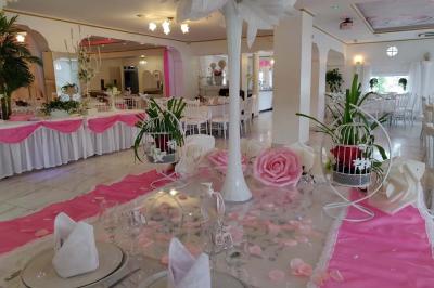 Décoration intérieure avec comptoir en marbre, plantes, ballons dorés et blancs disposés sur une structure décorative.