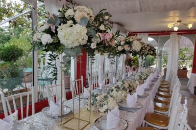 Décoration intérieure avec comptoir en marbre, plantes, ballons dorés et blancs disposés sur une structure décorative.
