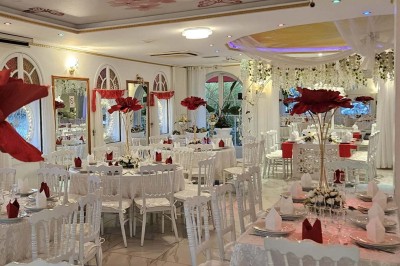 Décoration intérieure avec comptoir en marbre, plantes, ballons dorés et blancs disposés sur une structure décorative.