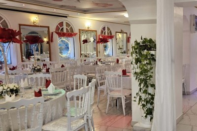 Décoration intérieure avec comptoir en marbre, plantes, ballons dorés et blancs disposés sur une structure décorative.