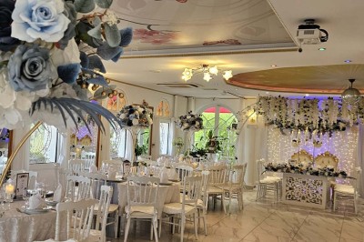 Décoration intérieure avec comptoir en marbre, plantes, ballons dorés et blancs disposés sur une structure décorative.