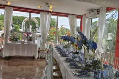 Décoration intérieure avec comptoir en marbre, plantes, ballons dorés et blancs disposés sur une structure décorative.