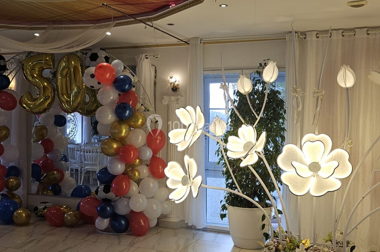 Location salle Athis-Mons (Essonne) - La Bella Vita #37 Décoration de salle avec arche de ballons colorés, chiffres ’50’ dorés et lampes en forme de fleurs lumineuses.