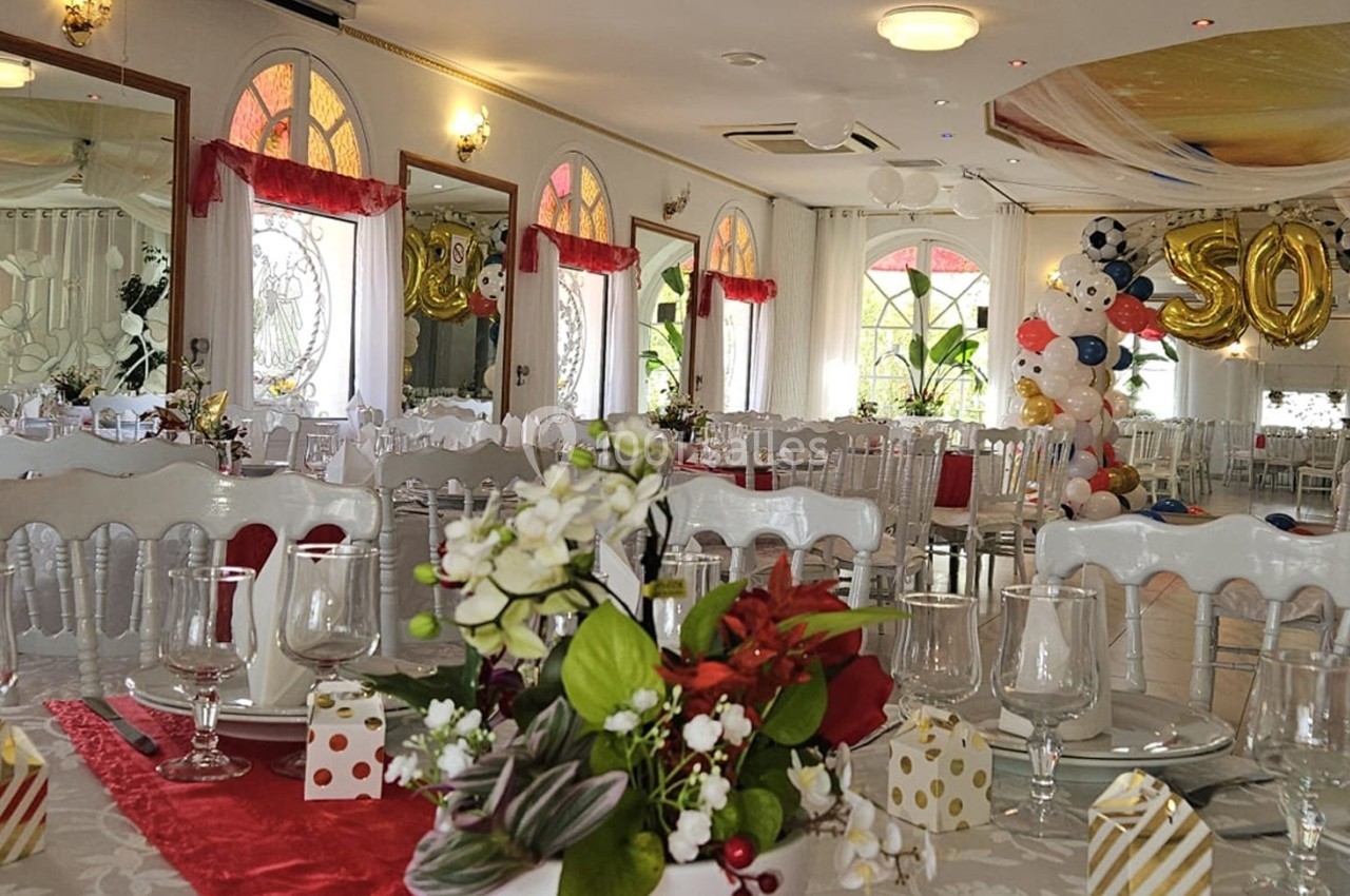 Location salle Athis-Mons (Essonne) - La Bella Vita #38 Salle de réception décorée avec des tables dressées, des ballons colorés et une arche marquée ’50’.