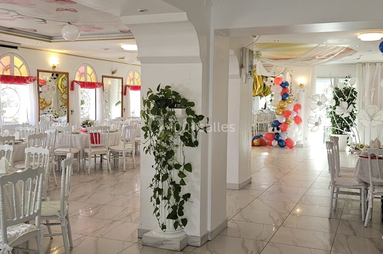 Location salle Athis-Mons (Essonne) - La Bella Vita #39 Salle de réception lumineuse décorée avec des tables dressées, des plantes et des ballons colorés au fond.