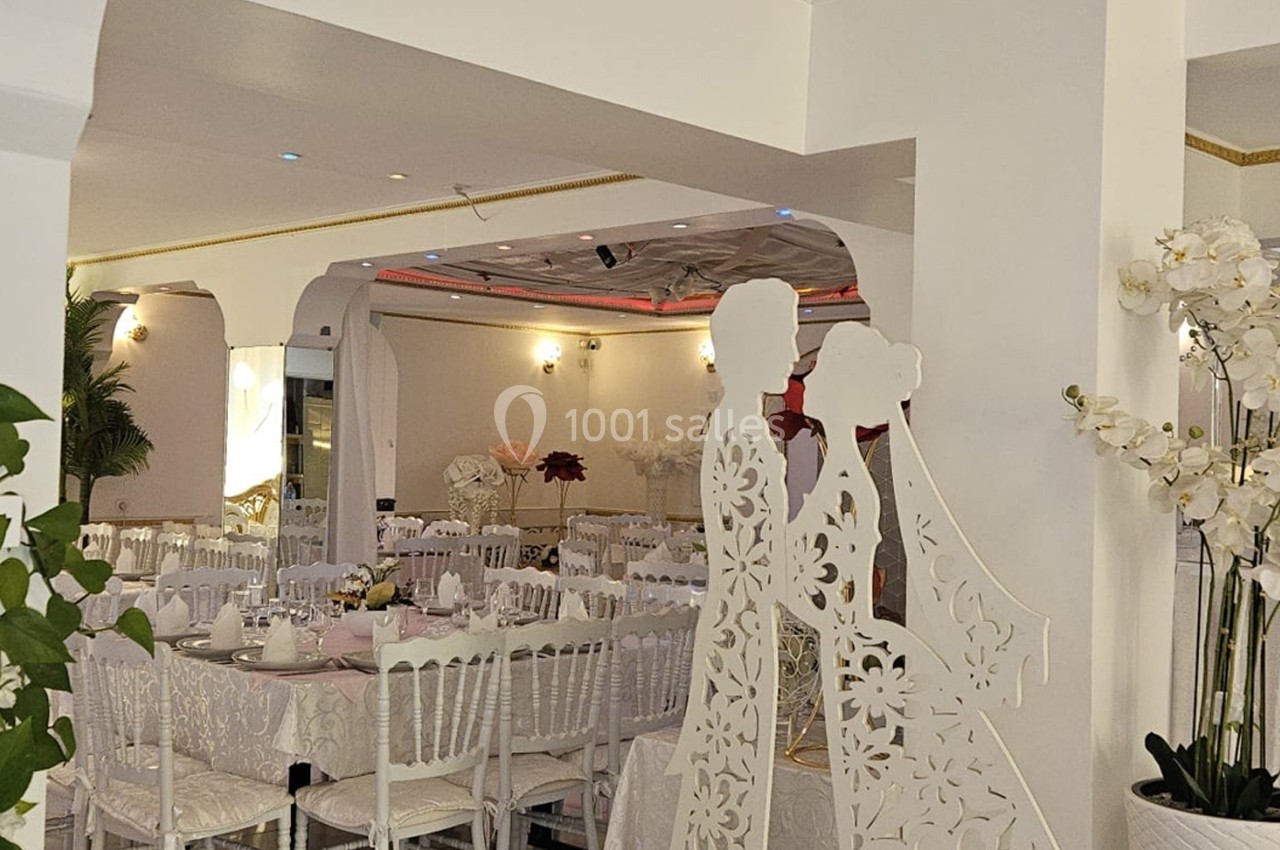 Location salle Athis-Mons (Essonne) - La Bella Vita #40 Salle de réception décorée avec des tables dressées, des chaises blanches et des ornements floraux blancs.