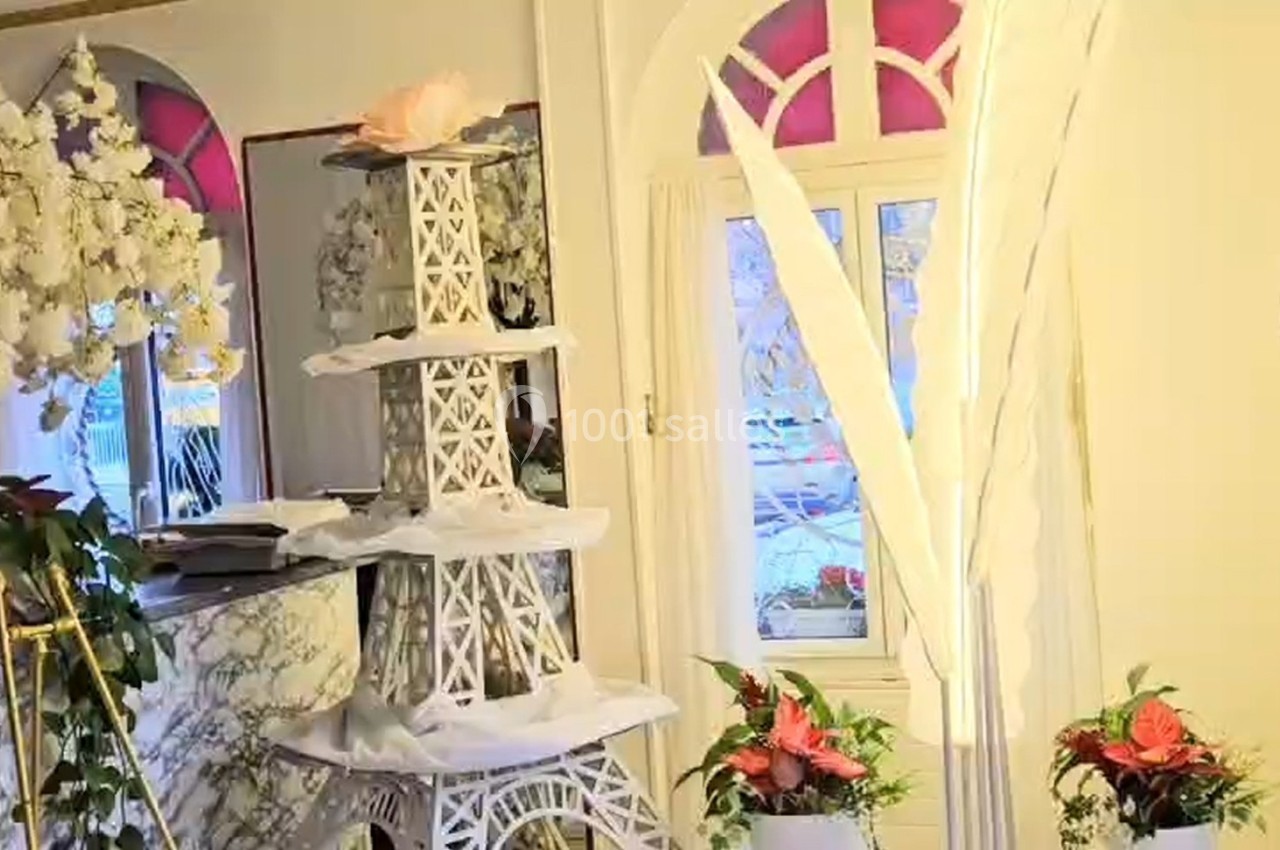 Location salle Athis-Mons (Essonne) - La Bella Vita #47 Décoration intérieure avec une tour Eiffel blanche ornée de fleurs, entourée de plantes et d'éléments floraux.