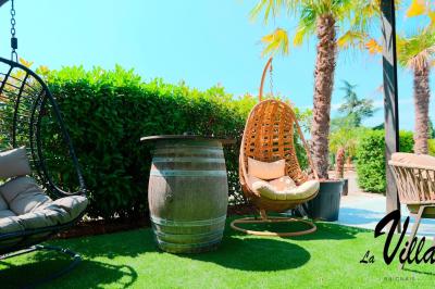 Salle avec un bar, tables hautes et éclairage violet, grandes fenêtres ouvertes sur une terrasse.