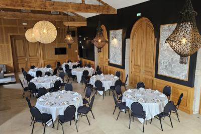 Salle avec un bar, tables hautes et éclairage violet, grandes fenêtres ouvertes sur une terrasse.