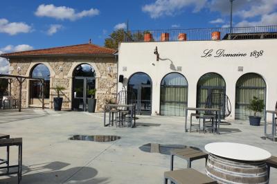 Salle avec un bar, tables hautes et éclairage violet, grandes fenêtres ouvertes sur une terrasse.