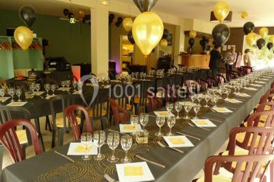 Cuisine professionnelle avec murs jaunes, plan de travail en inox, évier, cuisinière, fenêtre et équipements de rangement.