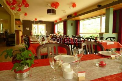 Cuisine professionnelle avec murs jaunes, plan de travail en inox, évier, cuisinière, fenêtre et équipements de rangement.