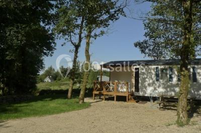 Cuisine professionnelle avec murs jaunes, plan de travail en inox, évier, cuisinière, fenêtre et équipements de rangement.