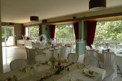 Cuisine professionnelle avec murs jaunes, plan de travail en inox, évier, cuisinière, fenêtre et équipements de rangement.