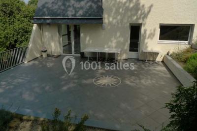 Cuisine professionnelle avec murs jaunes, plan de travail en inox, évier, cuisinière, fenêtre et équipements de rangement.