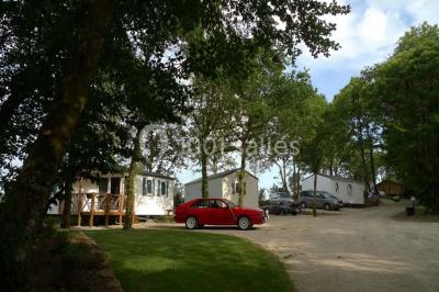 Cuisine professionnelle avec murs jaunes, plan de travail en inox, évier, cuisinière, fenêtre et équipements de rangement.