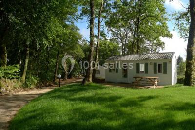 Cuisine professionnelle avec murs jaunes, plan de travail en inox, évier, cuisinière, fenêtre et équipements de rangement.