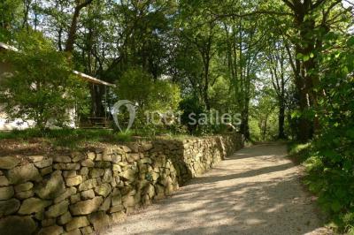 Cuisine professionnelle avec murs jaunes, plan de travail en inox, évier, cuisinière, fenêtre et équipements de rangement.