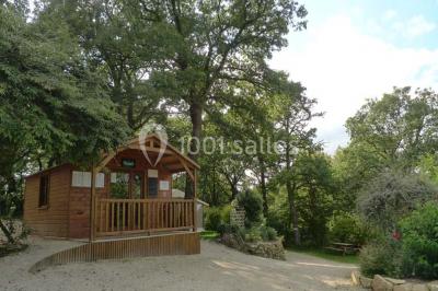 Cuisine professionnelle avec murs jaunes, plan de travail en inox, évier, cuisinière, fenêtre et équipements de rangement.