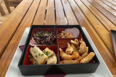 Bouteilles de vin rosé sur glace devant des parasols blancs et bleus sous un ciel dégagé.